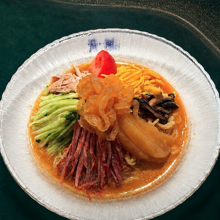 特製蒸し鶏、クラゲ、錦糸卵、椎茸、チャーシュー、胡瓜、トマト、林檎のコンポートを盛り付けた冷やし中華