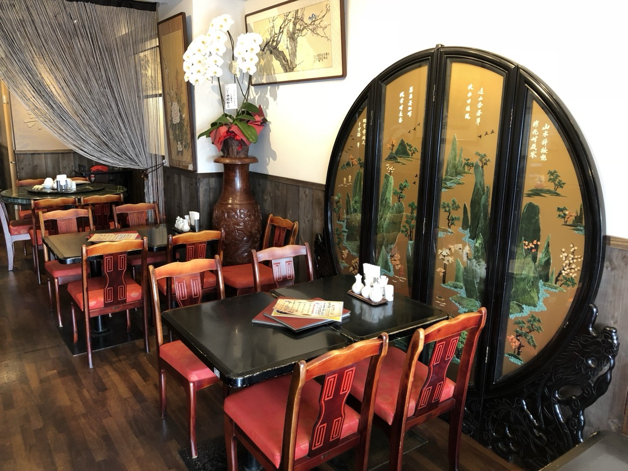 中国家具と赤い椅子が並ぶ青葉の店内